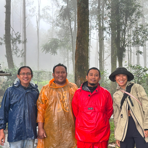 Jenny standing next to Omawild's first farm partners in Garut, West Java; alongside conservation educator Cecep and the main producer Faizal at the agroforestry coffee system.